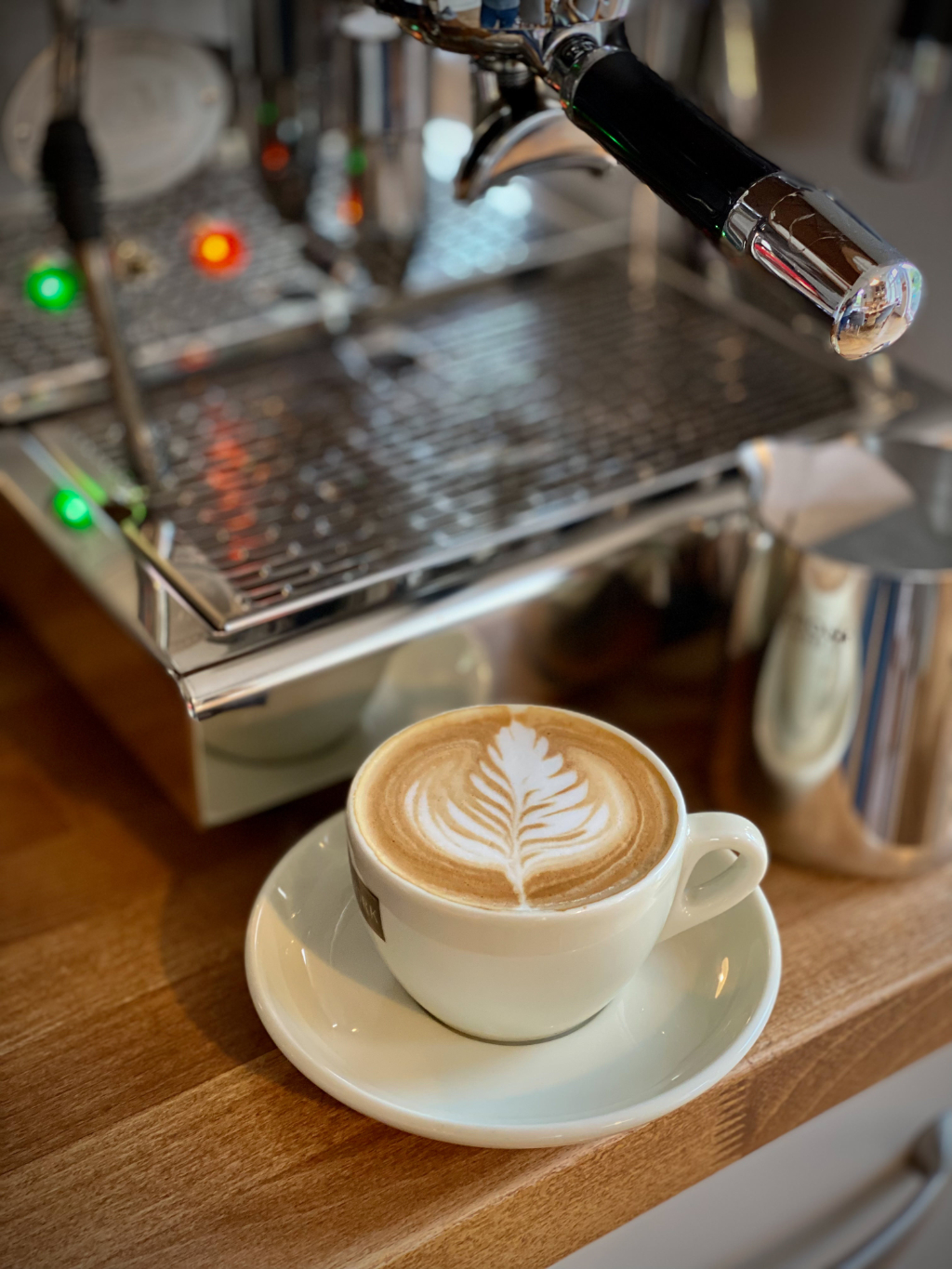 A photo of today’s first coffee I made, a flat white, standing in front of my espresso machine